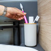 Magnetic soap dispenser and magnetic toothbrush cup including pads