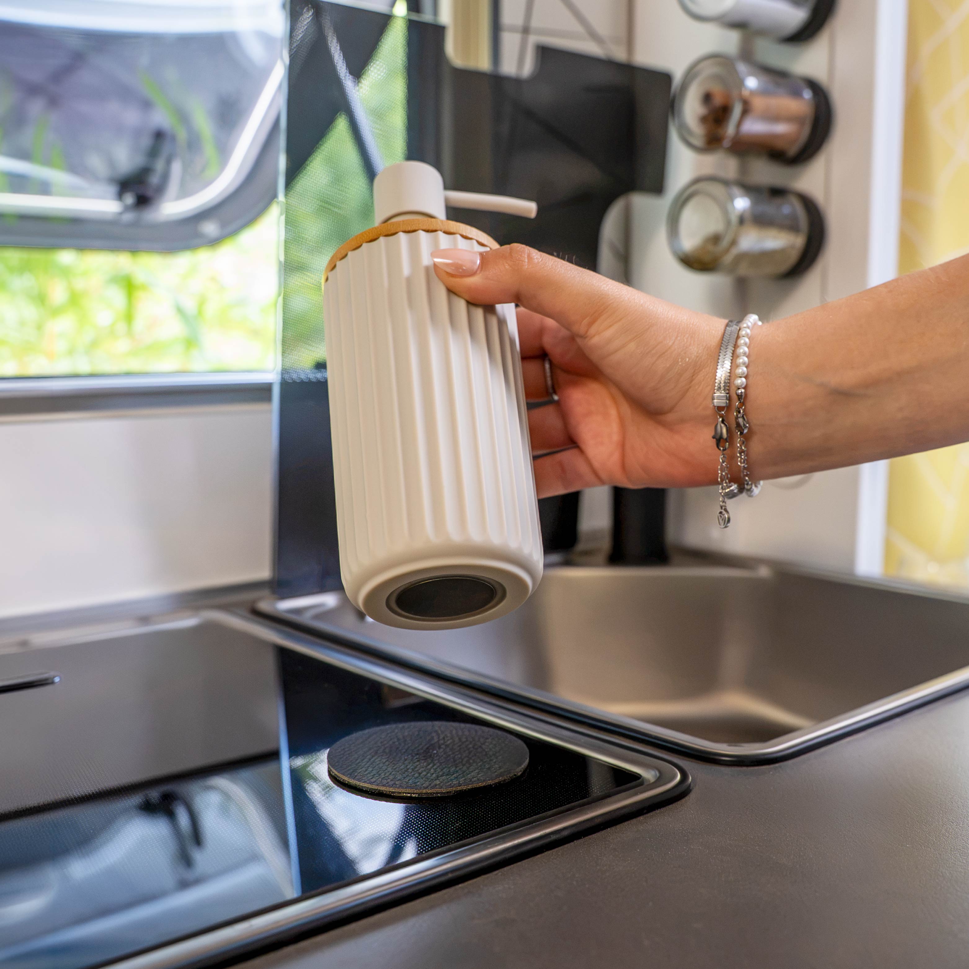 Magnetic soap dispenser and magnetic toothbrush cup including pads